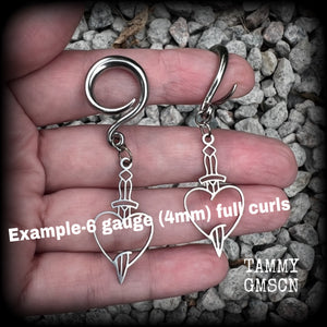 These awesome gauged earrings feature stainless steel heart and dagger charms, are nice and lightweight, weighing only 3 grams a piece, and nice and dangly at just on 6 cms from tip to tip.

This pair has been made on 6 gauge (4mm) surgical steel full curl hooks, suitable for stretched lobes.
