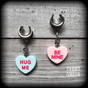 These adorable candy heart ear hangers feature mismatched Be mine and Hug me candy hearts, measuring just under 5cms from tip to tip, and weighing only a few grams each.
This pair has been made on 6 gauge (4mm) surgical steel full curl hooks, suitable for stretched lobes.
