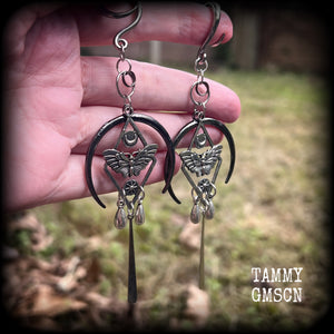 These gorgeous antique silver 'Moth and moon" gauged earrings feature an antique silver moth pendant sitting atop a black inverted crescent moon charm, dripping with antique silver teardrops.
Measuring just under 11cms, weighing approx 11 grams each.