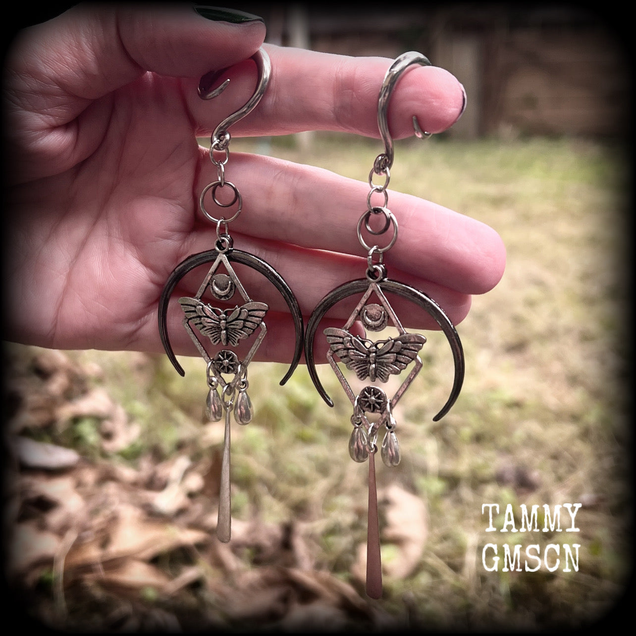 These gorgeous antique silver 'Moth and moon" gauged earrings feature an antique silver moth pendant sitting atop a black inverted crescent moon charm, dripping with antique silver teardrops.
Measuring just under 11cms, weighing approx 11 grams each.