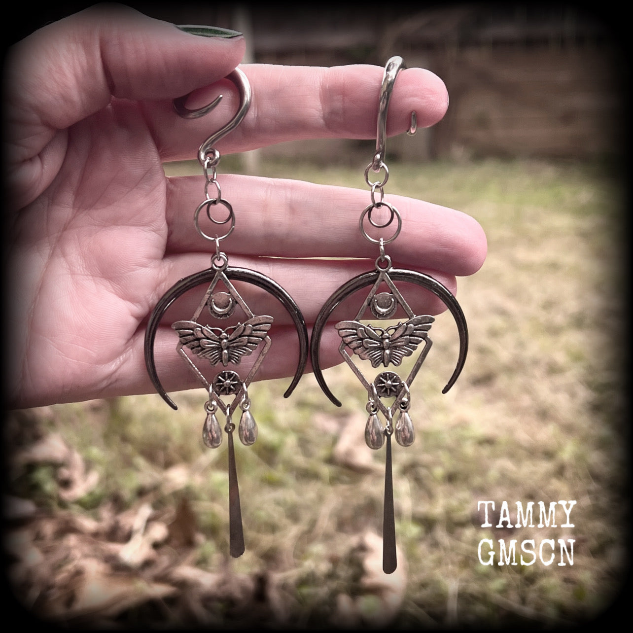 These gorgeous antique silver 'Moth and moon" gauged earrings feature an antique silver moth pendant sitting atop a black inverted crescent moon charm, dripping with antique silver teardrops.
Measuring just under 11cms, weighing approx 11 grams each.