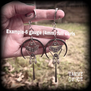 These gorgeous antique silver 'Moth and moon" gauged earrings feature an antique silver moth pendant sitting atop a black inverted crescent moon charm, dripping with antique silver teardrops.
Measuring just under 11cms, weighing approx 11 grams each.
