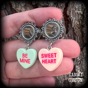 These adorable tunnel earrings feature cute candy hearts, are nice and lightweight, weighing only 6 grams each and measure just over 4cms from tip to tip.
This pair has been made with 1/2 (12mm) gauge ornate stainless steel screw fit tunnels.