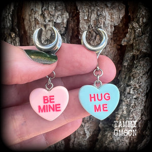 These adorable candy heart ear hangers feature mismatched Be mine and Hug me candy hearts, measuring just under 5cms from tip to tip, and weighing only a gram or two each.
This pair has been made on 00 gauge (10mm) surgical steel cradles.