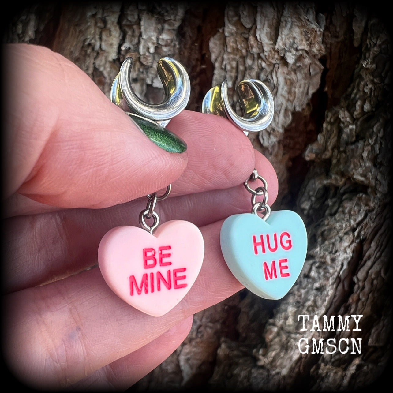 These adorable candy heart ear hangers feature mismatched Be mine and Hug me candy hearts, measuring just under 5cms from tip to tip, and weighing only a gram or two each.
This pair has been made on 00 gauge (10mm) surgical steel cradles.