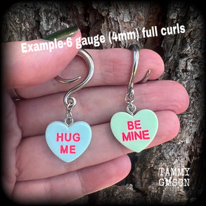These adorable candy heart ear hangers feature mismatched Be mine and Hug me candy hearts, measuring just under 5cms from tip to tip, and weighing only a few grams each.
This pair has been made on 6 gauge (4mm) surgical steel full curl hooks.