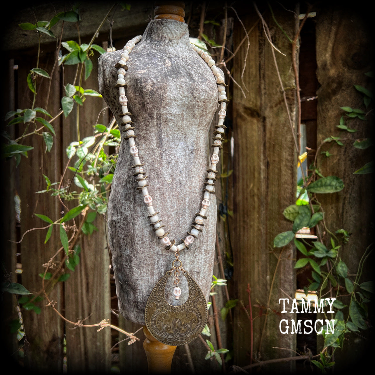 This unique necklace features a gorgeous antique bronze abstract snake pendant with a small bone white howlite stone skull dangling atop, on a strand of bone white stone and ornate antique bronze beads.
This necklace measures 44cms from tip to tip when laid flat and fastens with an antique bronze lobster clasp.