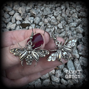 These awesome earrings feature antique silver scarab beetles with wings open revealing a skull on its body, measuring just under 4cms, and weighing only a few grams each.

This pair has been made on stainless steel french hooks, for pierced ears.