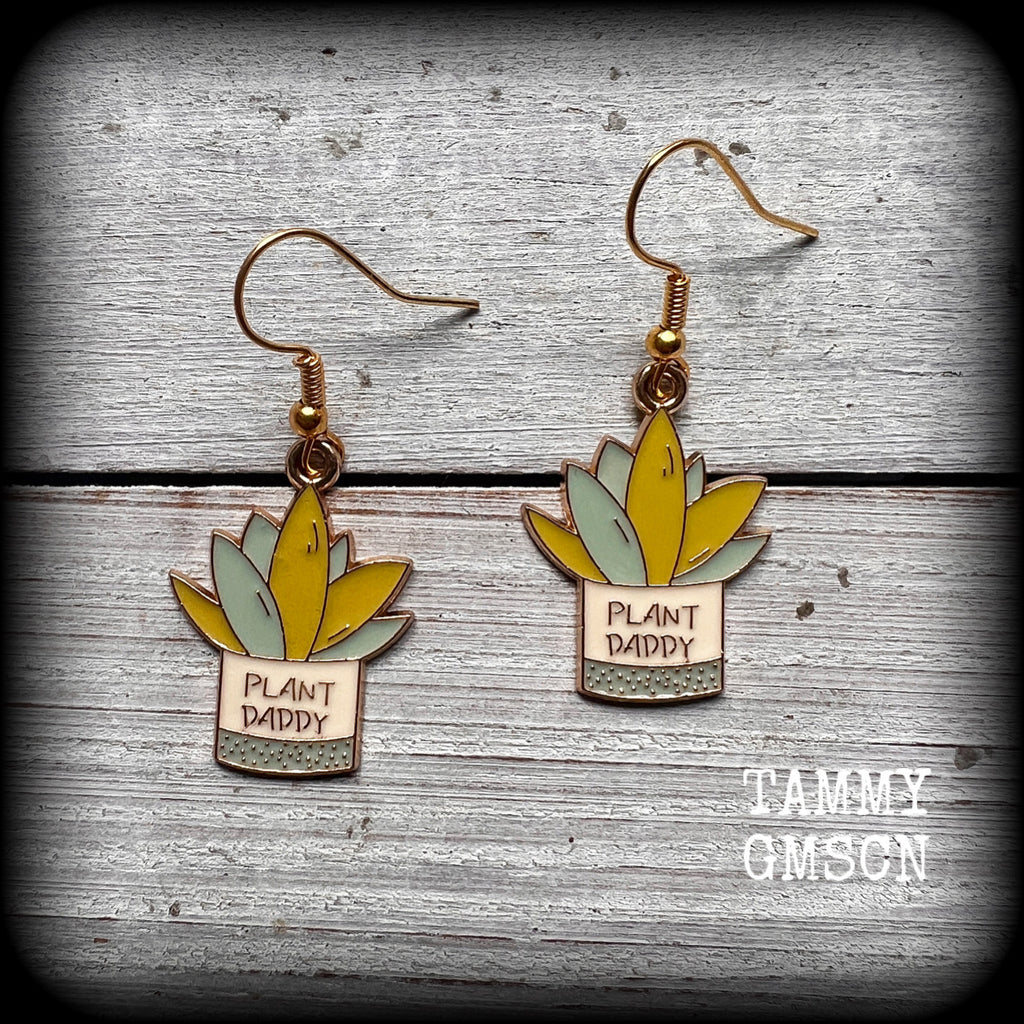 These quirky earrings feature an antique gold and enamel potted ‘PLANT DADDY’ plant, measuring just on 5cms from top to bottom, and weighing only a few grams each.

This pair has been made on antique gold french hooks, suitable for pierced ears.

