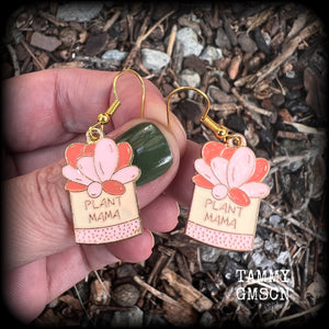 These quirky earrings feature an antique gold and enamel potted ‘PLANT MAMA’ plant, measuring just on 5cms from top to bottom, and weighing only a few grams each.
This pair has been made on antique gold french hooks, suitable for pierced ears.