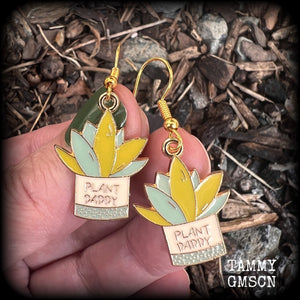These quirky earrings feature an antique gold and enamel potted ‘PLANT DADDY’ plant, measuring just on 5cms from top to bottom, and weighing only a few grams each.
This pair has been made on antique gold french hooks, suitable for pierced ears.