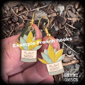 These quirky earrings feature an antique gold and enamel potted ‘PLANT DADDY’ plant, measuring just on 5cms from top to bottom, and weighing only a few grams each.
This pair has been made on antique gold french hooks, suitable for pierced ears.