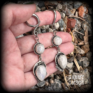 These gorgeous earrings feature polished Rainbow Moonstone gemstones in a beautiful boho antique silver setting, lovely and dangly at approx 8cms from tip to tip, and not too heavy at 9 grams each.
This pair had been made on 6 gauge (4mm) surgical steel full curl hooks, to be worn in stretched lobes.