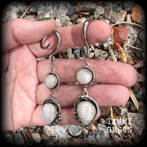 These gorgeous earrings feature polished Rainbow Moonstone gemstones in a beautiful boho antique silver setting, lovely and dangly at approx 8cms from tip to tip, and not too heavy at 9 grams each.
This pair had been made on 6 gauge (4mm) surgical steel full curl hooks, to be worn in stretched lobes.