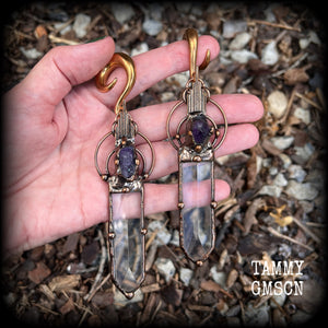 These beautiful oversized gauged earrings feature big clear quartz daggers with raw amethyst gemstones in a unique copper setting. These gorgeous earrings are nice and long, measuring 13cms from tip to tip, and weighing approx 47 grams each.
This pair has been made on 0 gauge (8mm) rose gold tone surgical steel full curl hooks, suitable for stretched lobes.