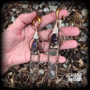 These beautiful oversized gauged earrings feature big clear quartz daggers with raw amethyst gemstones in a unique copper setting. These gorgeous earrings are nice and long, measuring 13cms from tip to tip, and weighing approx 47 grams each.
This pair has been made on 0 gauge (8mm) rose gold tone surgical steel full curl hooks, suitable for stretched lobes.