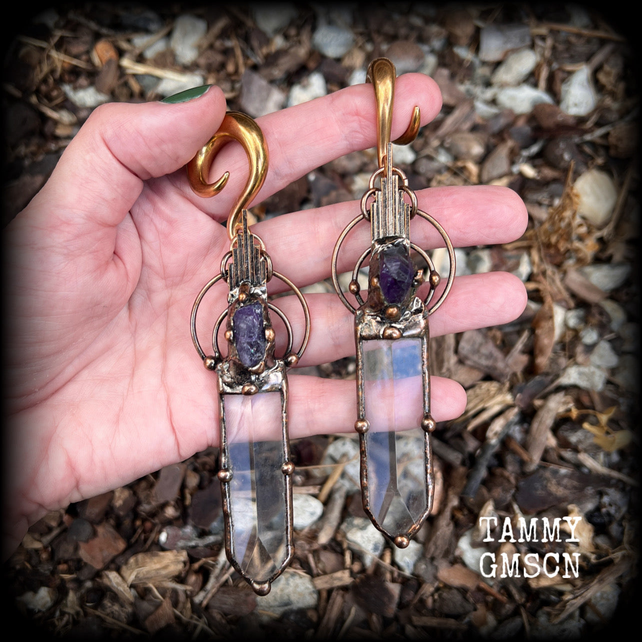 These beautiful oversized gauged earrings feature big clear quartz daggers with raw amethyst gemstones in a unique copper setting. These gorgeous earrings are nice and long, measuring 13cms from tip to tip, and weighing approx 47 grams each.
This pair has been made on 0 gauge (8mm) rose gold tone surgical steel full curl hooks, suitable for stretched lobes.