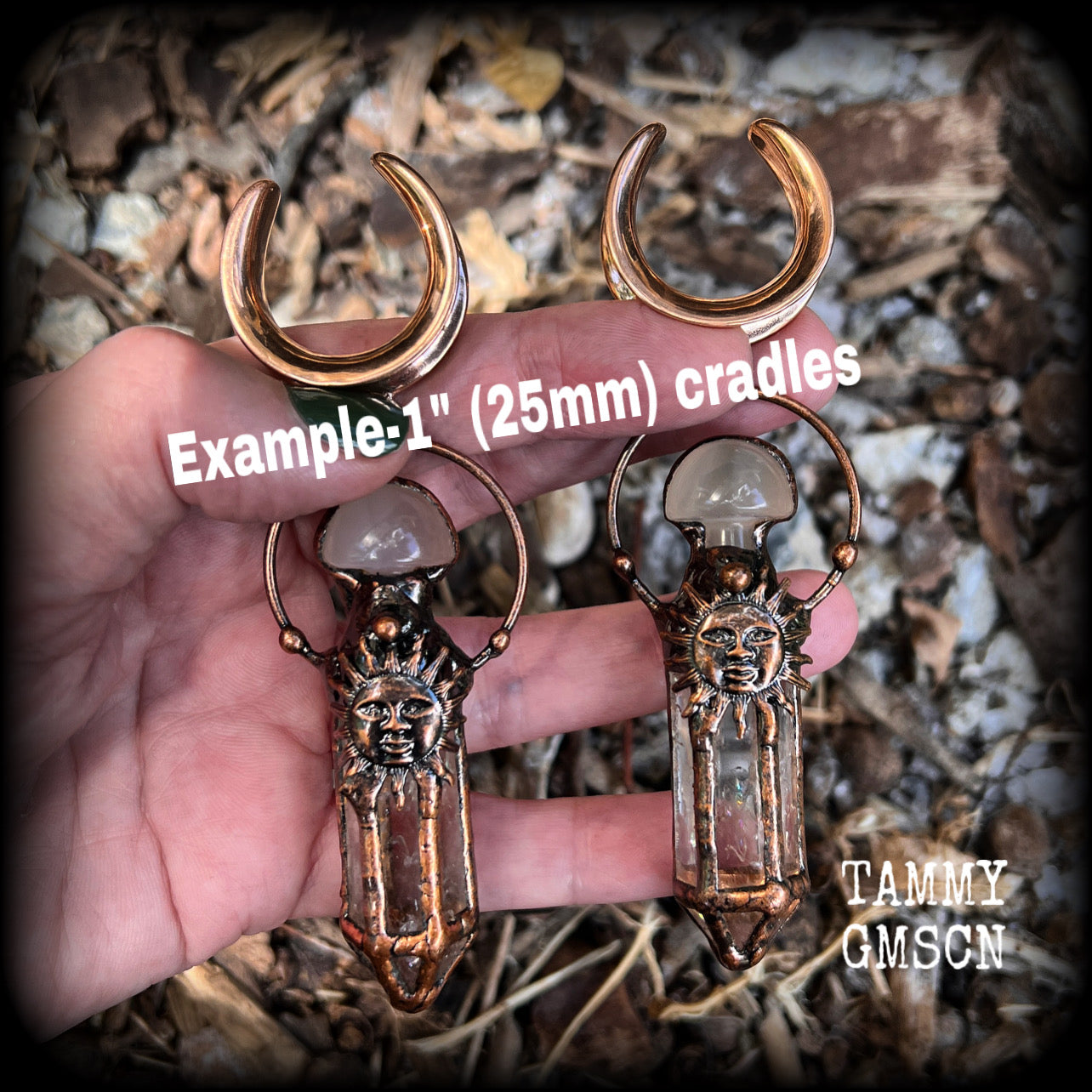 These unique ear weights feature big clear quartz points enclosed in a copper electroplate cage with topped with folk horror inspired celestial suns. These gorgeous earrings measure 11cms from tip to tip, and weigh approx 45 grams each.
This pair has been made on 1” gauge (25mm) rose gold tone surgical steel cradles, suitable for stretched lobes.
