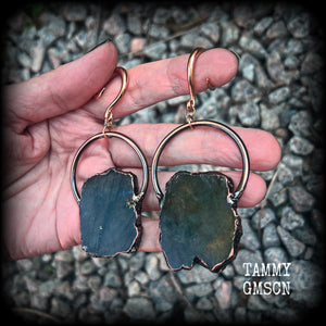 This pair of gorgeous earrings features large shimmering labradorite slices with rustic ornate copper plate detail, weighing approx 22 grams a piece, not too heavy, and measuring just on 9cms from tip to tip.

These earrings have been made on 6 gauge (4mm) surgical steel full curl hooks, to be worn in stretched lobes.