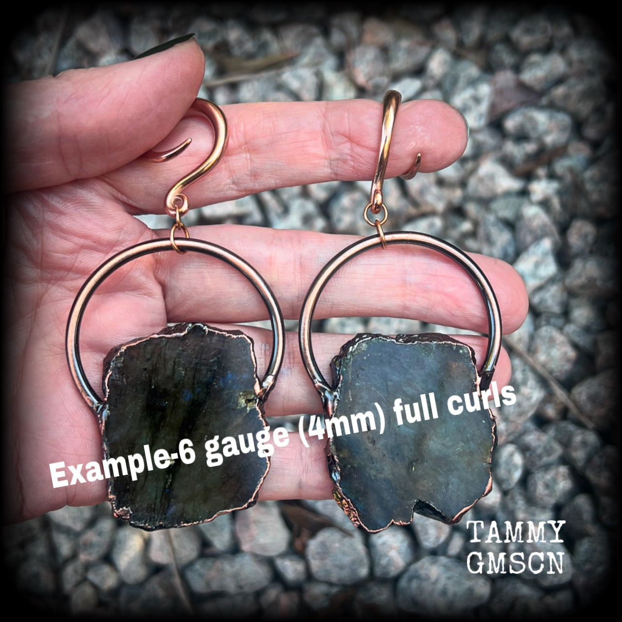 This pair of gorgeous earrings features large shimmering labradorite slices with rustic ornate copper plate detail, weighing approx 22 grams a piece, not too heavy, and measuring just on 9cms from tip to tip.

These earrings have been made on 6 gauge (4mm) surgical steel full curl hooks, to be worn in stretched lobes.