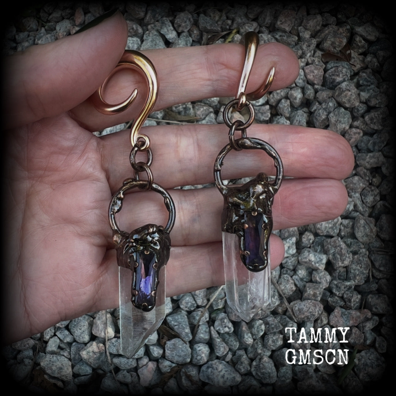 These clear quartz and amethyst gauged earrings are simply gorgeous!!
Featuring gorgeous amethyst stones sitting on front of chunky quartz pillars in an antique copper setting, these gauged earrings measure just on 9.5cms from tip to tip, and weigh approx 25 grams each.
This pair has been made on 6 gauge (4mm) surgical steel full curl hooks, suitable to be worn in stretched lobes.