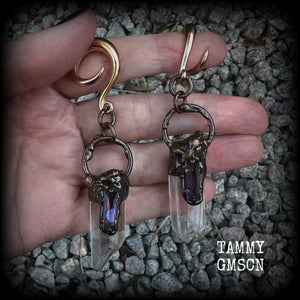 These clear quartz and amethyst gauged earrings are simply gorgeous!!
Featuring gorgeous amethyst stones sitting on front of chunky quartz pillars in an antique copper setting, these gauged earrings measure just on 9.5cms from tip to tip, and weigh approx 25 grams each.
This pair has been made on 6 gauge (4mm) surgical steel full curl hooks, suitable to be worn in stretched lobes.