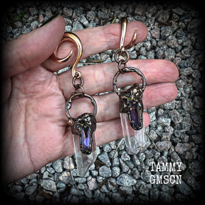 These clear quartz and amethyst gauged earrings are simply gorgeous!!
Featuring gorgeous amethyst stones sitting on front of chunky quartz pillars in an antique copper setting, these gauged earrings measure just on 9.5cms from tip to tip, and weigh approx 25 grams each.
This pair has been made on 6 gauge (4mm) surgical steel full curl hooks, suitable to be worn in stretched lobes.