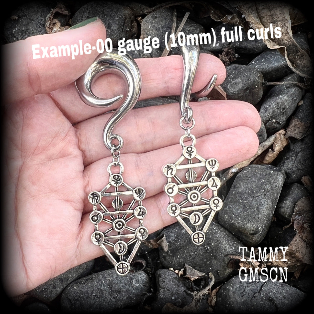 Our 'Tree of Life' gauged earrings feature stunning Kabalistic Tree of Life charms complete with sephiroth symbols. These earrings and are nice and dangly at just on 7cms, and weigh 8 grams a piece.
This pair has been made on 00 gauge (10mm) surgical steel full curl hooks, to be worn in stretched lobes.