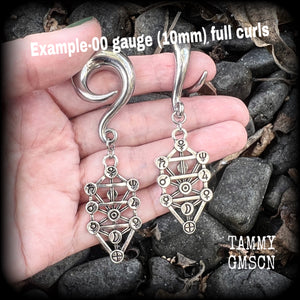 Our 'Tree of Life' gauged earrings feature stunning Kabalistic Tree of Life charms complete with sephiroth symbols. These earrings and are nice and dangly at just on 7cms, and weigh 8 grams a piece.
This pair has been made on 00 gauge (10mm) surgical steel full curl hooks, to be worn in stretched lobes.