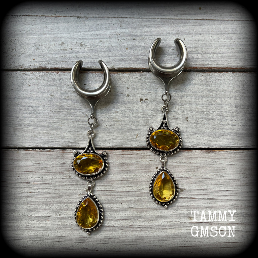 These earrings feature beautiful dangly yellow citrine gemstones in a gorgeous boho antique silver setting, lovely and dangly at just on 8.5cms from tip to tip, and weighing approx 11 grams each.
These earrings have been made on 5/8” gauge (16mm) surgical steel cradles, to be worn in stretched lobes.

