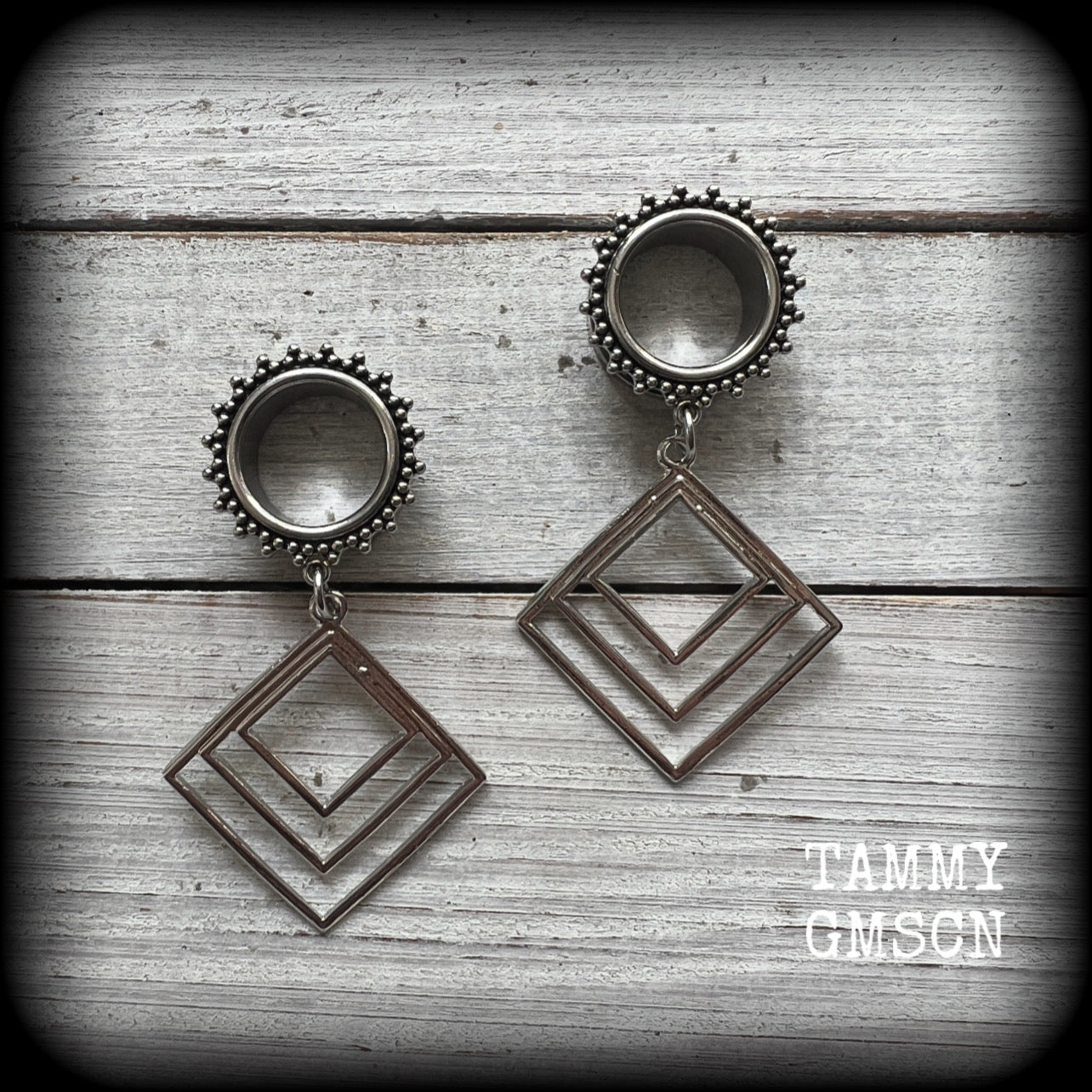These gorgeous geometric tunnels feature 3 nestled antique silver diamonds, are lovely and dangly measuring just over 6 cms from tip to tip, and nice and light weight, weighing approx 9 grams each.
This pair has been made with 5/8" gauge (16mm) ornate surgical steel tunnels, suitable for stretched lobes.