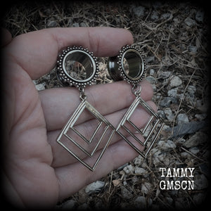 These gorgeous geometric tunnels feature 3 nestled antique silver diamonds, are lovely and dangly measuring just over 6 cms from tip to tip, and nice and light weight, weighing approx 9 grams each.
This pair has been made with 5/8" gauge (16mm) ornate surgical steel tunnels, suitable for stretched lobes.