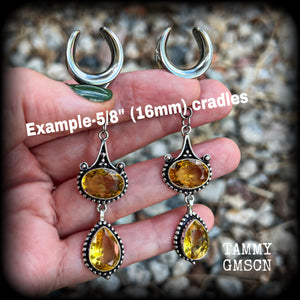 These earrings feature beautiful dangly yellow citrine gemstones in a gorgeous boho antique silver setting, 8.5cms from tip to tip, and weighing 11 grams each.
These earrings have been made on 5/8” gauge (16mm) surgical steel cradles.
