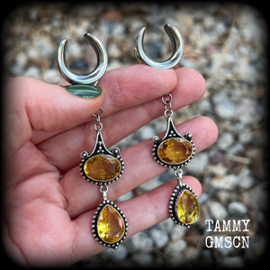 These earrings feature beautiful dangly yellow citrine gemstones in a gorgeous boho antique silver setting, 8.5cms from tip to tip, and weighing 11 grams each.
These earrings have been made on 5/8” gauge (16mm) surgical steel cradles.