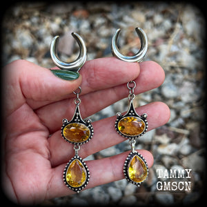 These earrings feature beautiful dangly yellow citrine gemstones in a gorgeous boho antique silver setting, 8.5cms from tip to tip, and weighing 11 grams each.
These earrings have been made on 5/8” gauge (16mm) surgical steel cradles.