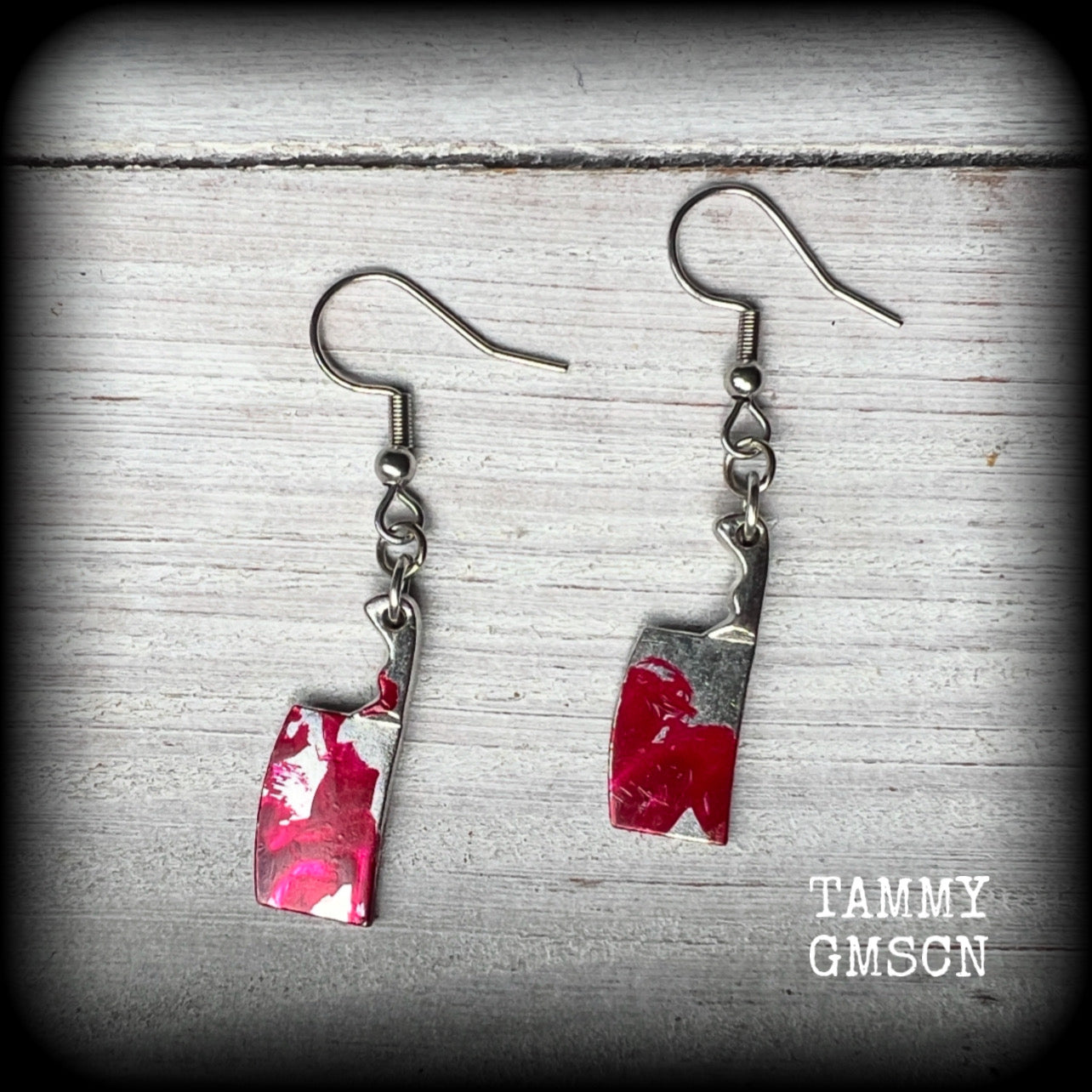 These awesome horror movie inspired earrings feature classic antique silver meat cleavers smeared with b l o o d. 
Measuring 5cms from tip to tip and weighing only 2 grams each, these are lovely and lightweight and nice and dangly.
