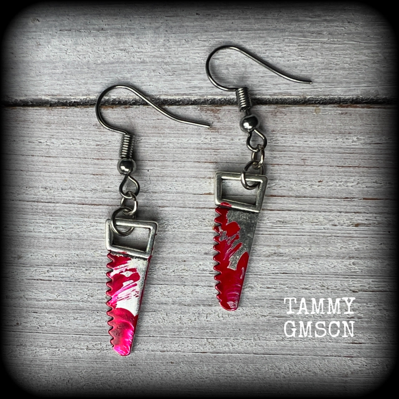 These awesome horror punk inspired earrings feature a pair of gorey b l o o d i e d bone saws, nice and light weight at only a gram or two each and measuring just over 4 cms from tip to tip.

This pair has been made on stainless steel french hooks for pierced ears. 