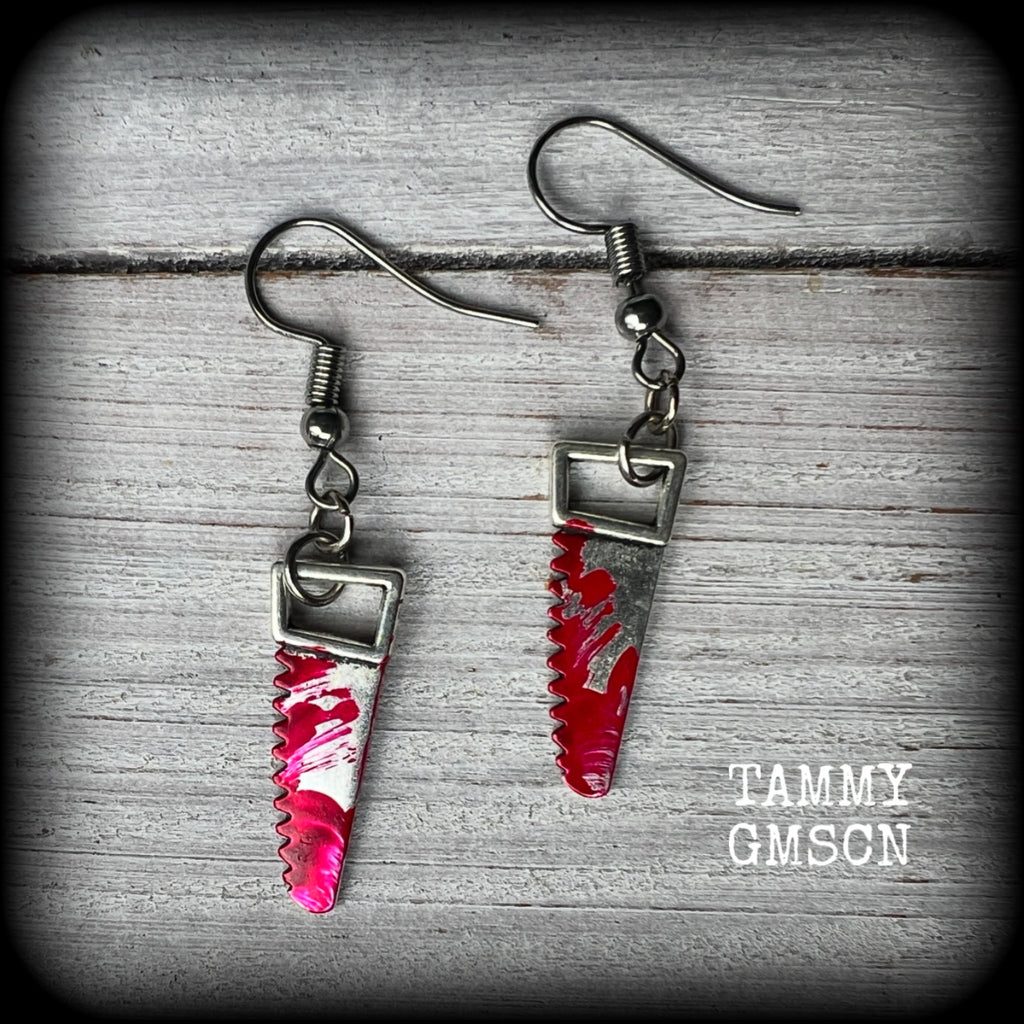 These awesome horror punk inspired earrings feature a pair of gorey b l o o d i e d bone saws, nice and light weight at only a gram or two each and measuring just over 4 cms from tip to tip.

This pair has been made on stainless steel french hooks for pierced ears. 