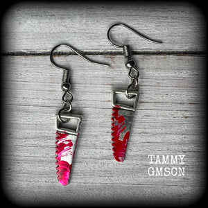 These awesome horror punk inspired earrings feature a pair of gorey b l o o d i e d bone saws, nice and light weight at only a gram or two each and measuring just over 4 cms from tip to tip.

This pair has been made on stainless steel french hooks for pierced ears. 