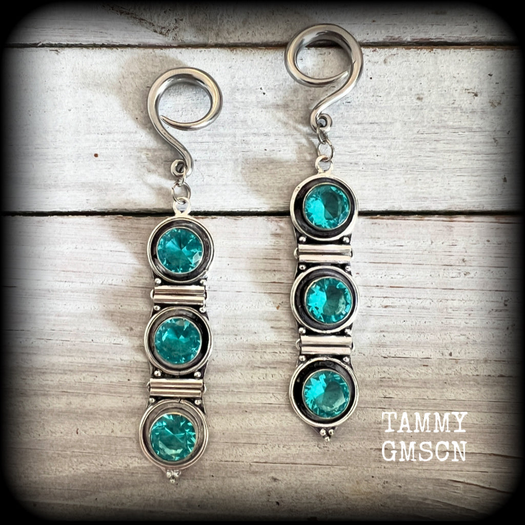 These earrings have been made with gorgeous facet ocean blue topaz gemstones in a beautifully boho antique silver setting, lovely and dangly at approx 9.5cms from tip to tip, and not too heavy at only 11 grams each.

These earrings have been made on 6 gauge (4mm) surgical steel full curl hooks, to be worn in stretched lobes.