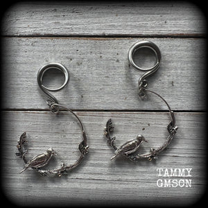 Featuring a gorgeous antique silver bird sitting on a branch wrapped with beautiful leafy vines, these delicate earrings measure just on 6.5 cms from tip to tip, and weigh approx 8 grams.
This pair have been made on 6 gauge (4mm) stainless steel full curl hooks, suitable for stretched lobes.