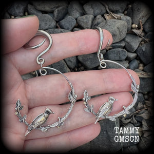 Featuring a gorgeous antique silver bird sitting on a branch wrapped with beautiful leafy vines, these delicate earrings measure just on 6.5 cms from tip to tip, and weigh approx 8 grams.
This pair have been made on 6 gauge (4mm) stainless steel full curl hooks, suitable for stretched lobes.
