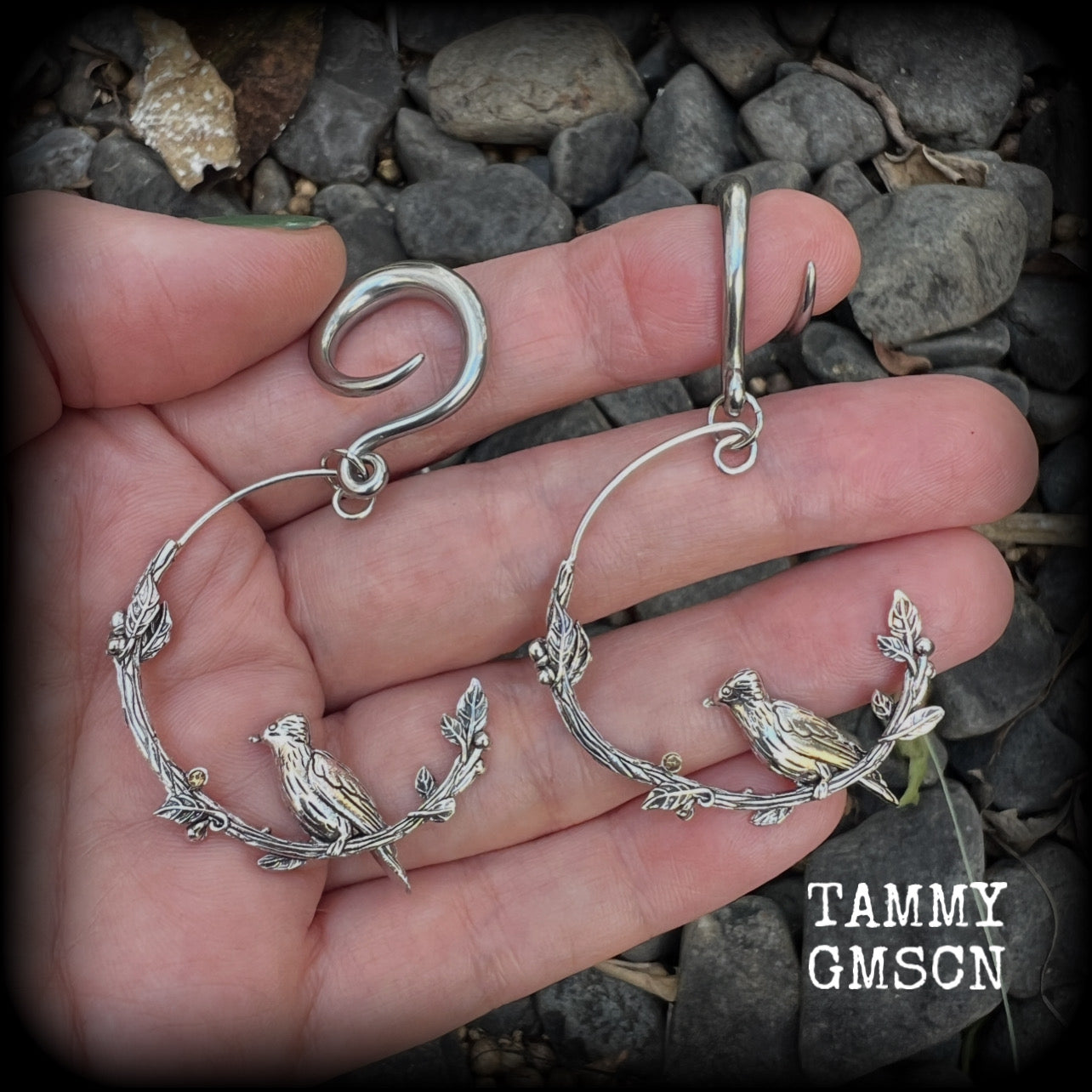 Featuring a gorgeous antique silver bird sitting on a branch wrapped with beautiful leafy vines, these delicate earrings measure just on 6.5 cms from tip to tip, and weigh approx 8 grams.
This pair have been made on 6 gauge (4mm) stainless steel full curl hooks, suitable for stretched lobes.