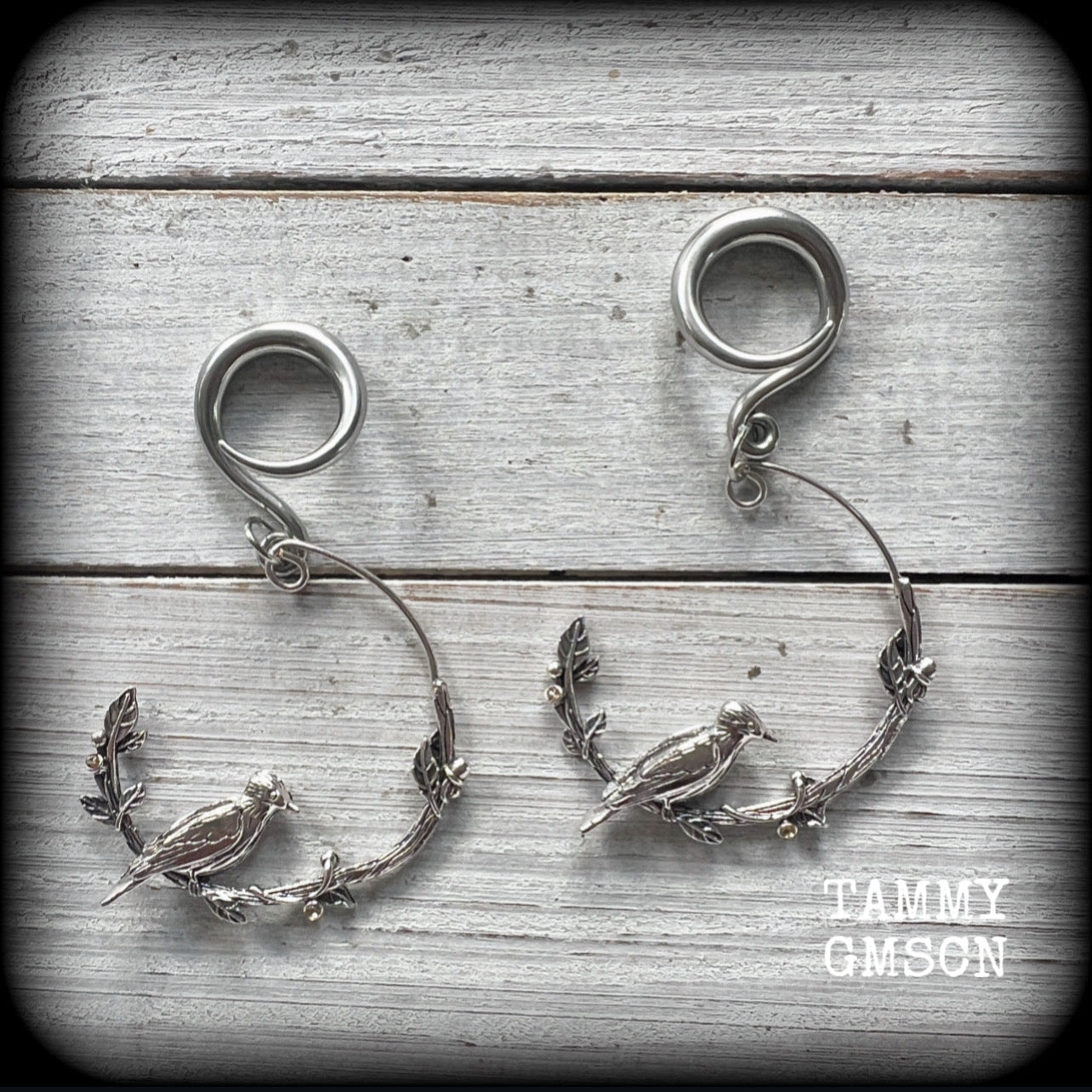 Featuring a gorgeous antique silver bird sitting on a branch wrapped with beautiful leafy vines, these delicate earrings measure  6.5 cms from tip to tip, and weigh 8 grams.
This pair have been made on 6 gauge (4mm) surgical steel full curl hooks.