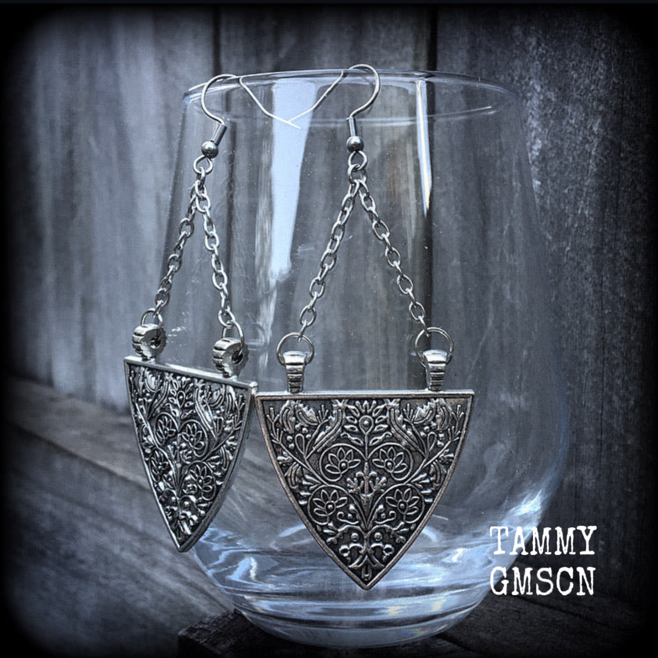 Inspired by Artemis, Goddess of the Hunt, these earrings feature a gorgeous inverted triangle shield adorned with beautiful ornate art nouveau inspired florals. 
These earrings weigh in at just 12 grams each, and are nice and dangly, measuring just on 10cms from tip to tip. 
These have been made on stainless steel french hooks, suitable for pierced ears.
