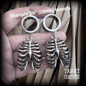 These spooky cute tunnel dangles feature a stsinless steel rigcage, weighing in at approx 18 grams each and measuring 6cms from tip to tip.
This pair have been made with 3/4” gauge (19mm) surgical steel screw fit tunnels, suitable for stretched lobes.