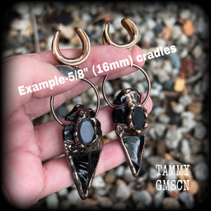 Featuring a gorgeous pitch black obsidian arrowhead in an antique copper setting, these earrings measure approx 10cms from tip to tip, and weigh approx 24 grams each. 
This pair has been made on 5/8” gauge (16mm) surgical steel cradles.