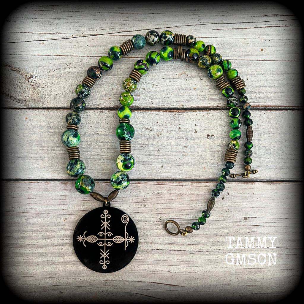 🔥 Papa Legba is the gatekeeper between the human and spirit worlds, and no human can reach the other spirits without Papa Legba’s permission. At the spiritual crossroads, Papa Legba decides whether a person is allowed to speak with other spirits 🔥

As with all the pieces in our Papa Legba range, this necklace is made with stone skulls in rich, beautiful, earthy organic colours, in honour of Papa Legba.

This necklace features gorgeous forest green kamababa jasper and antique bronze beads, with a black tit