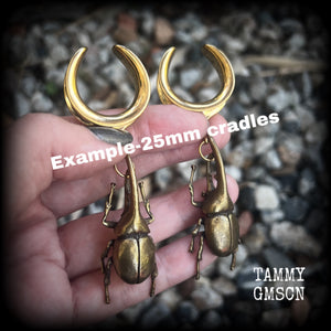 These awesome brass rhinoceros beetle ear hangers feature gorgeous brass rhinoceros beetle pendants, measuring just on 8cms from tip to tip, and weighing approx 23 grams each.
This pair has been made on 25mm surgical steel cradles, suitable for stretched lobes.