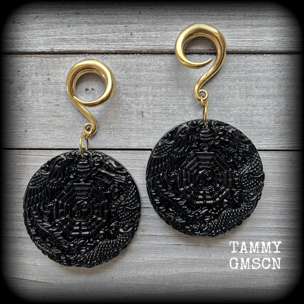 These gorgeous gauged earrings feature carved black obsidian pendants, showing a phoenix and dragon encircling the I-Ching hexagram.
These earrings weigh approx. 35 grams each and measuring just under 9cms from tip to tip.
This pair has been made with 2 gauge (6mm) surgical steel full curls, suitable for stretched lobes.